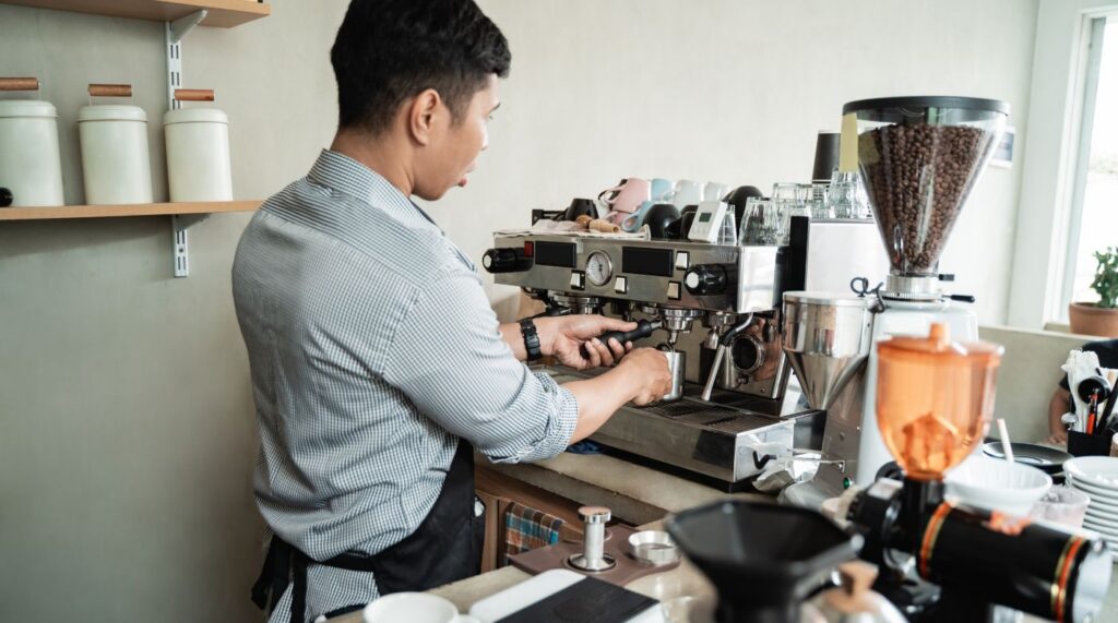 a barista makes coffee behind the counter of a coffee shop